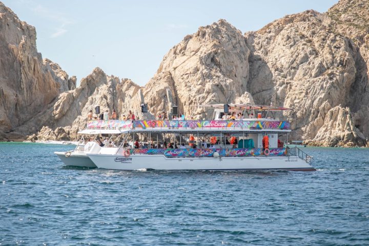a large ship in a body of water with a mountain in the background