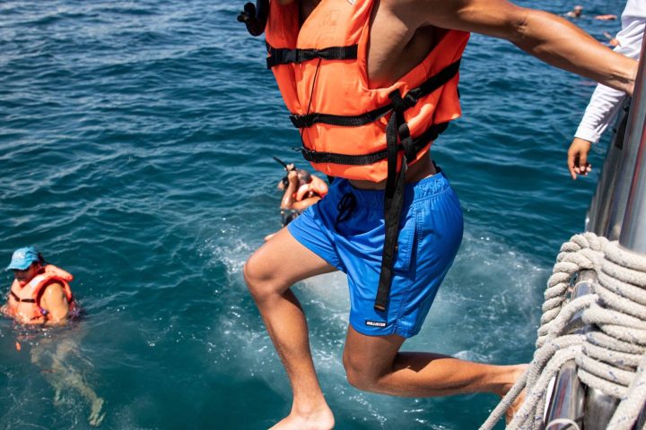 a group of people riding on the back of a boat in the water