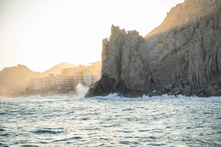 water next to the ocean with Arch of Cabo San Lucas in the background