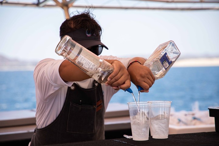 a man holding a glass of beer on a table