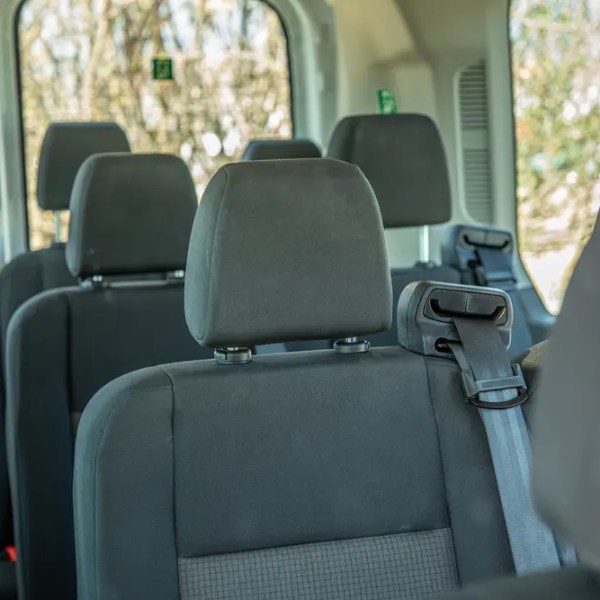 Empty minivan interior with gray fabric seats and seatbelts.